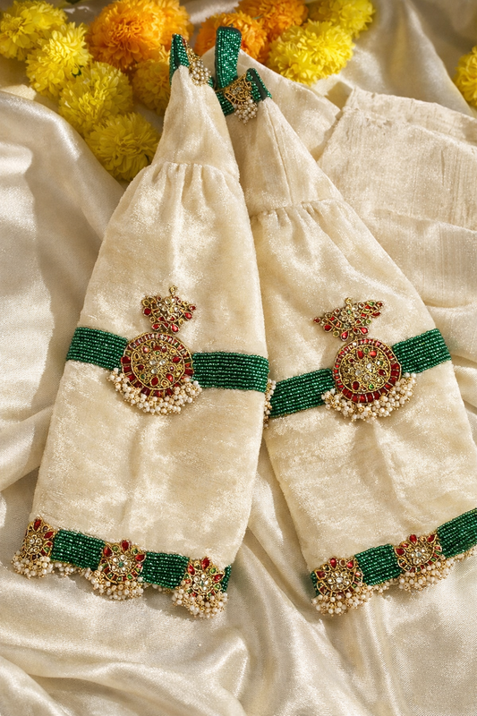 Cream silk velvet choker blouse flatlay with marigold garlands and kundan beadwork detailing