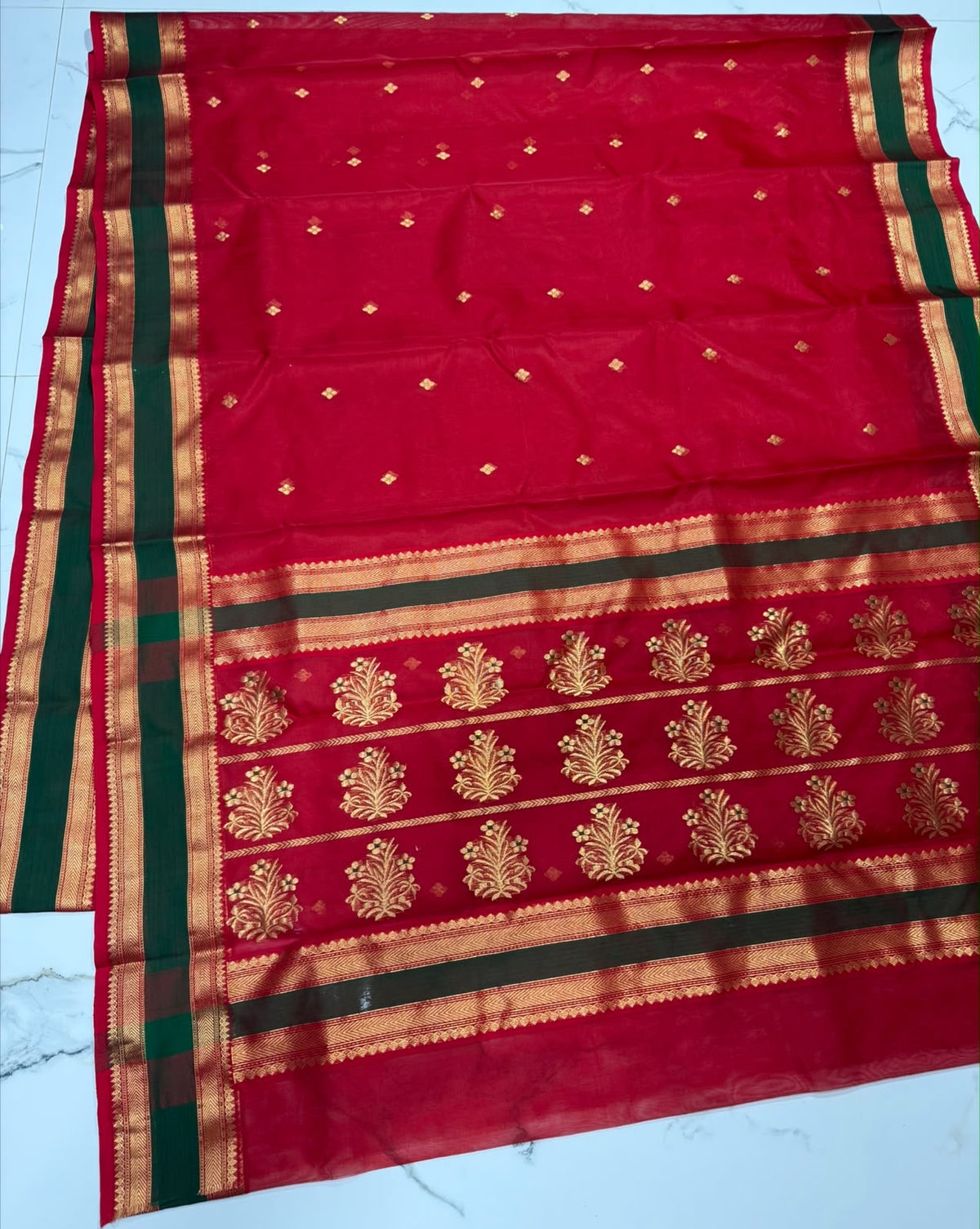 Close-up of the forest green and gold zari border on crimson red Chanderi silk