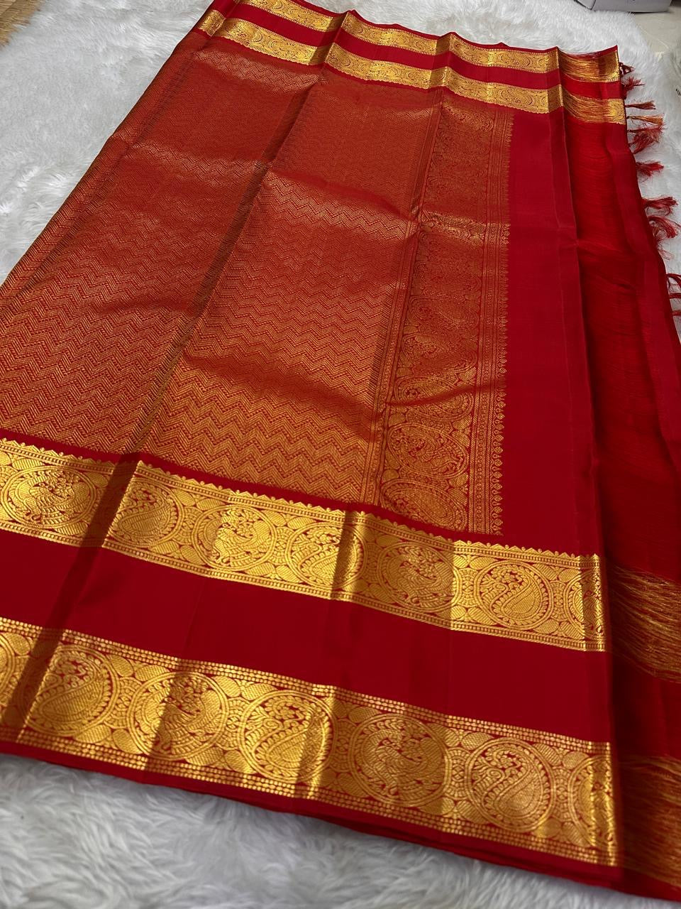 Crimson Red Kanchipuram Zari Kattam saree showing fine gold checked body and a broad traditional Sorgavasal Mayil and Manga border.