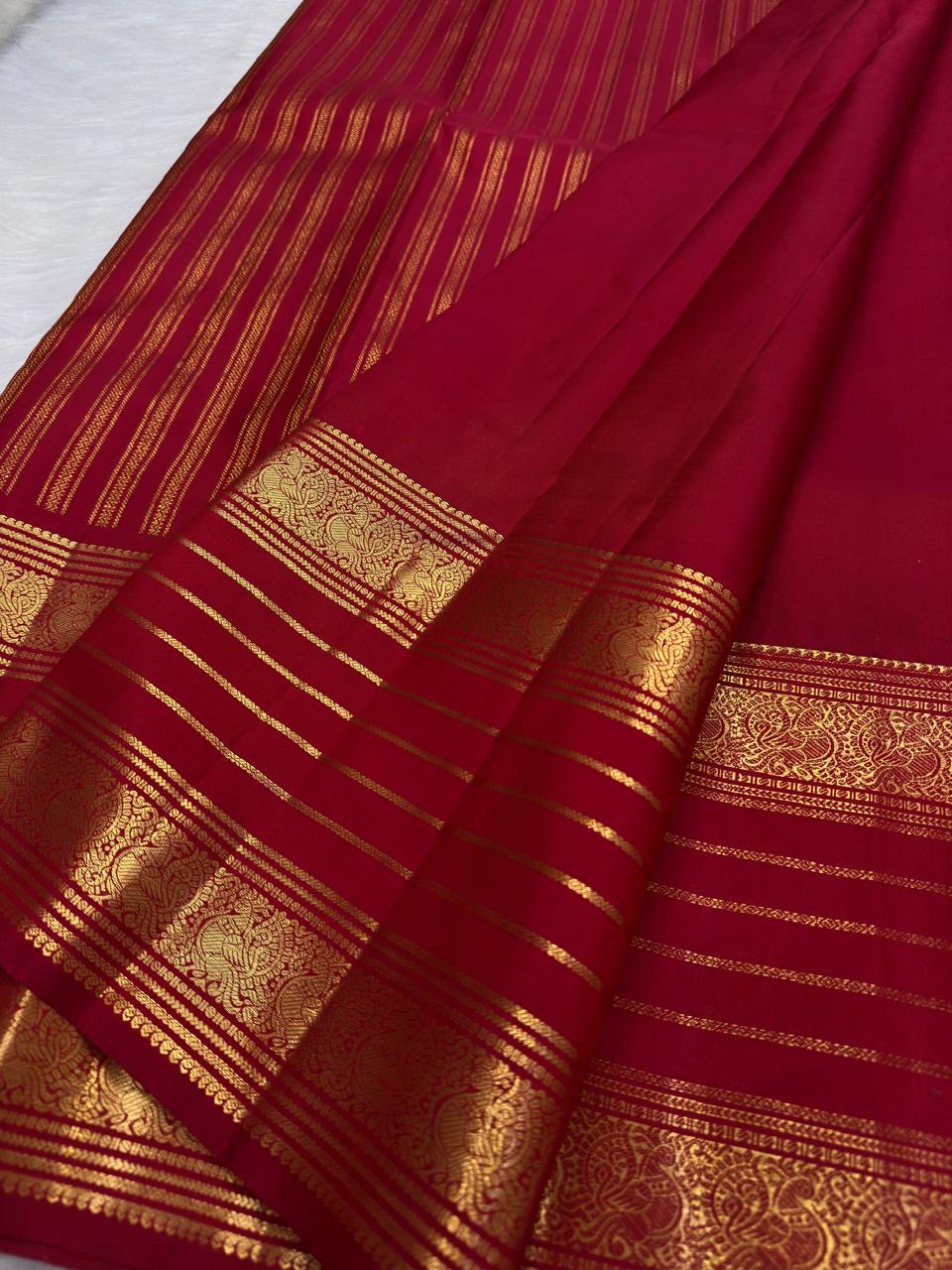 Vermilion Pinkish Red silk fold catching light beside handwoven gold zari buttas and border