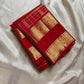 Folded Crimson Red Pure Silk Kanchipuram Zari Kattam saree with a large ornamental gold zari Sorgavasal Mayil and Manga border.