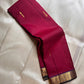 Draped maroon Pure Kanchipuram silk saree showing scattered zari buttas and a gold zari woven border with a dark edge finish.