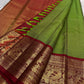 Handwoven Kanjeevaram Korvai saree featuring betel leaf green body and dramatic vermilion red contrast pallu