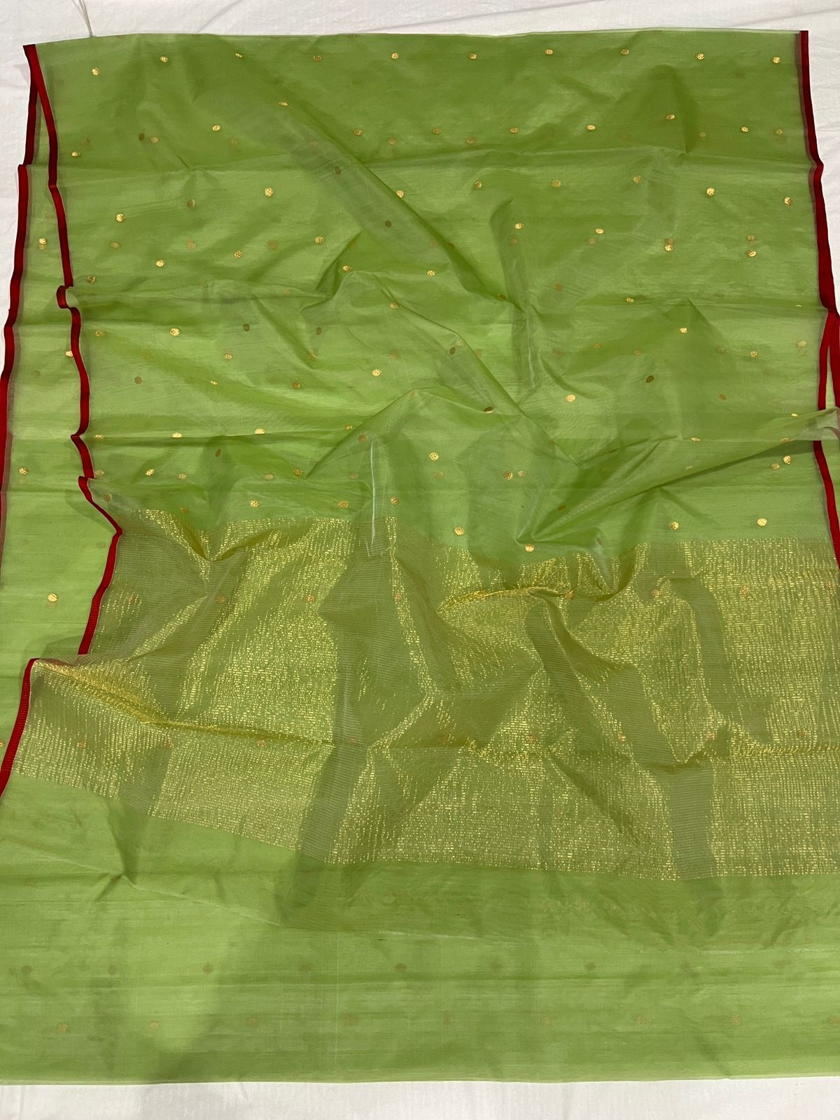 Close view of green Chanderi silk with gold woven buttas, deep red border and fine gold zari