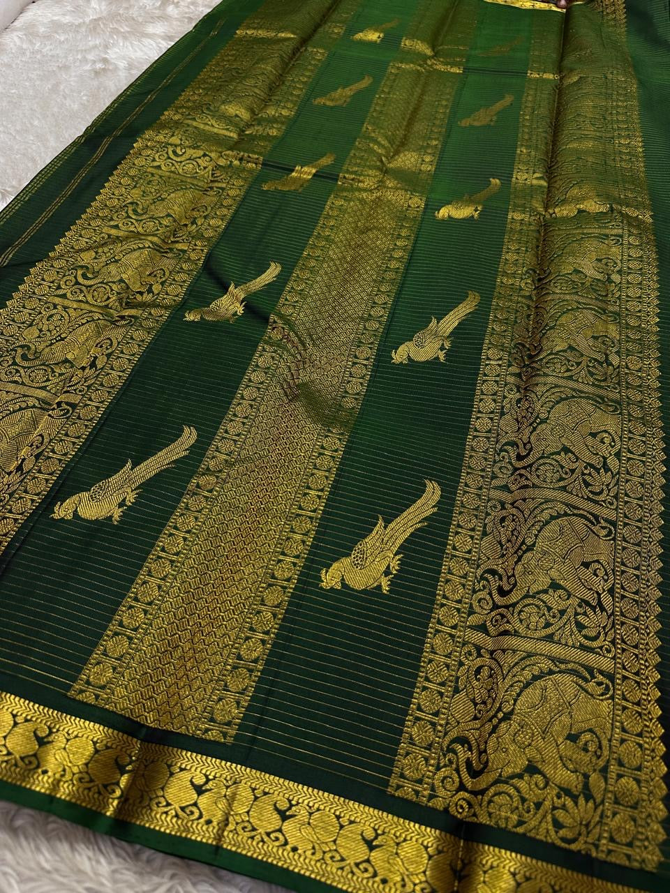 Ornate self-colour Mayil peacock border of dark bottle green Kanjipuram saree with dense antique gold zari Varisaipet bands