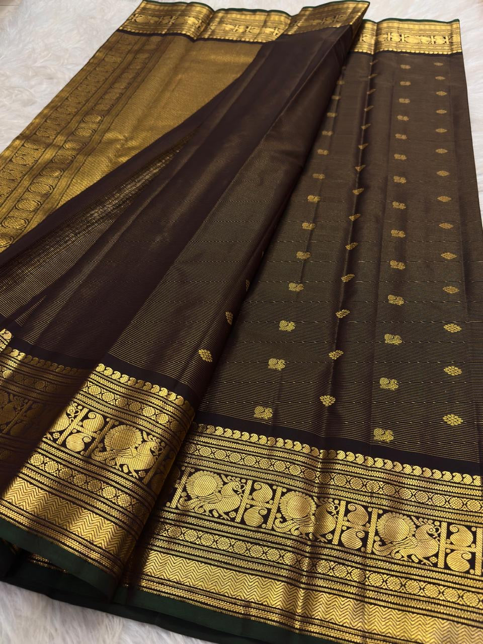 Close-up of the brown silk surface and woven zari work on this Kanchipuram saree.