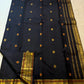 Close view of black silk with spaced meenakari buttas and a broad classic-gold border.