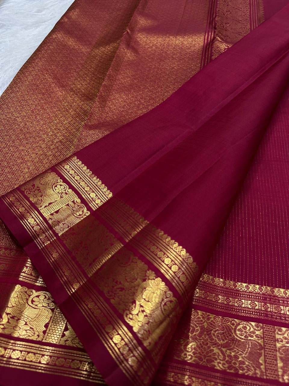 Deep red Kanchipuram saree with Yazhi and Mayil zari border