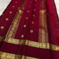 Arakku Red Kanchipuram silk saree with spaced gold buttas and fine zari lines running lengthwise.