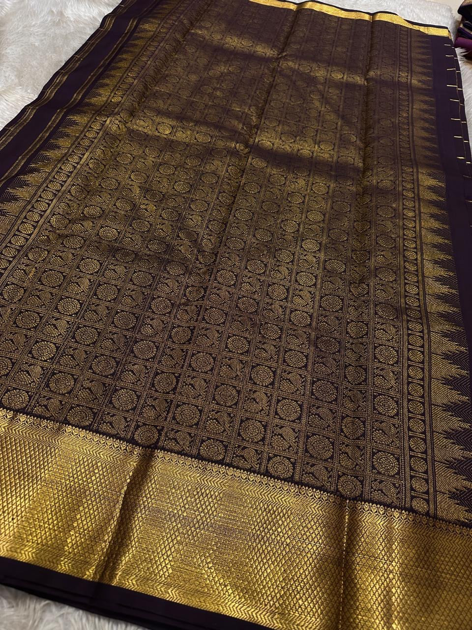 Close view of antique gold Mayil border and Zari Kattam body on Deep Coffee Brown Pure Silk Kanchipuram saree.