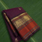 Deep aubergine Kanchipuram silk saree with antique gold zari and burnt vermilion korvai border.