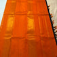 Folded Kanchana Brownish Purple saree showing narrow orange and gold zari edge.
