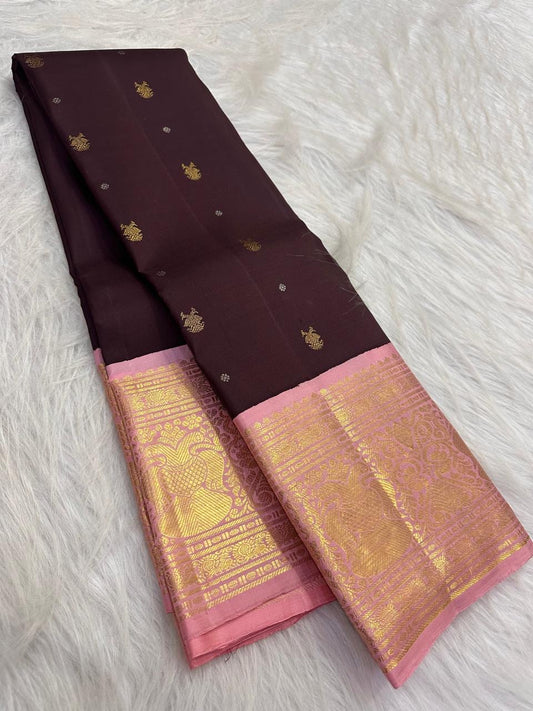 Deep brown aubergine Kanchipuram silk saree with spaced gold zari motifs and contrasting pink Korvai border.
