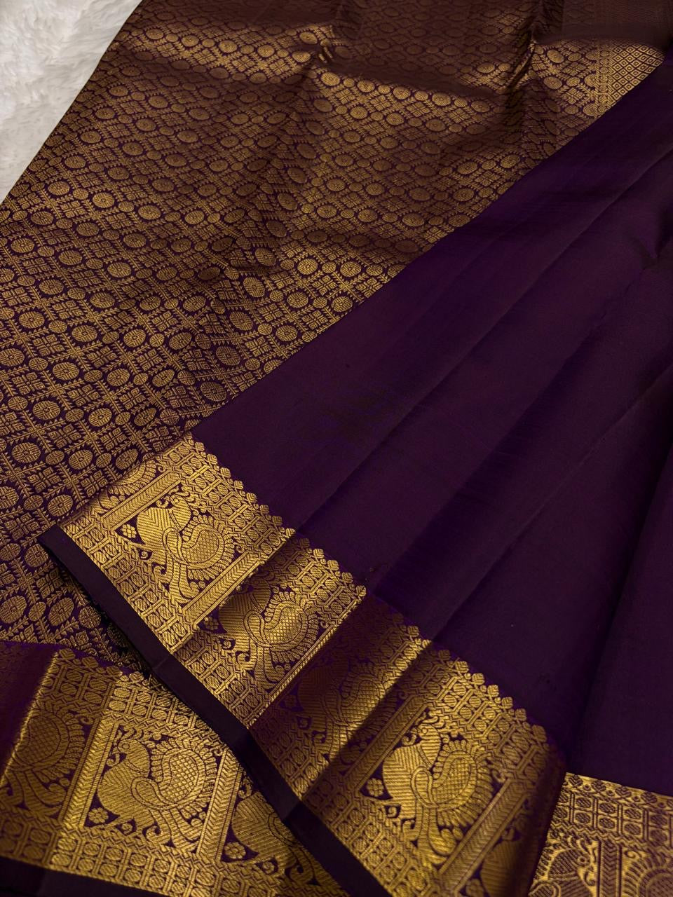 Aubergine Purple Kanchipuram silk saree with petite gold zari buttas and intricate Mayil border