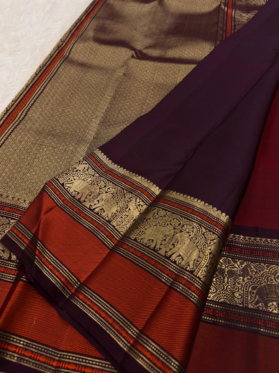 Close view of elephant gold zari motifs framed by ornamental arches on Kanchipuram Varisaipet border.