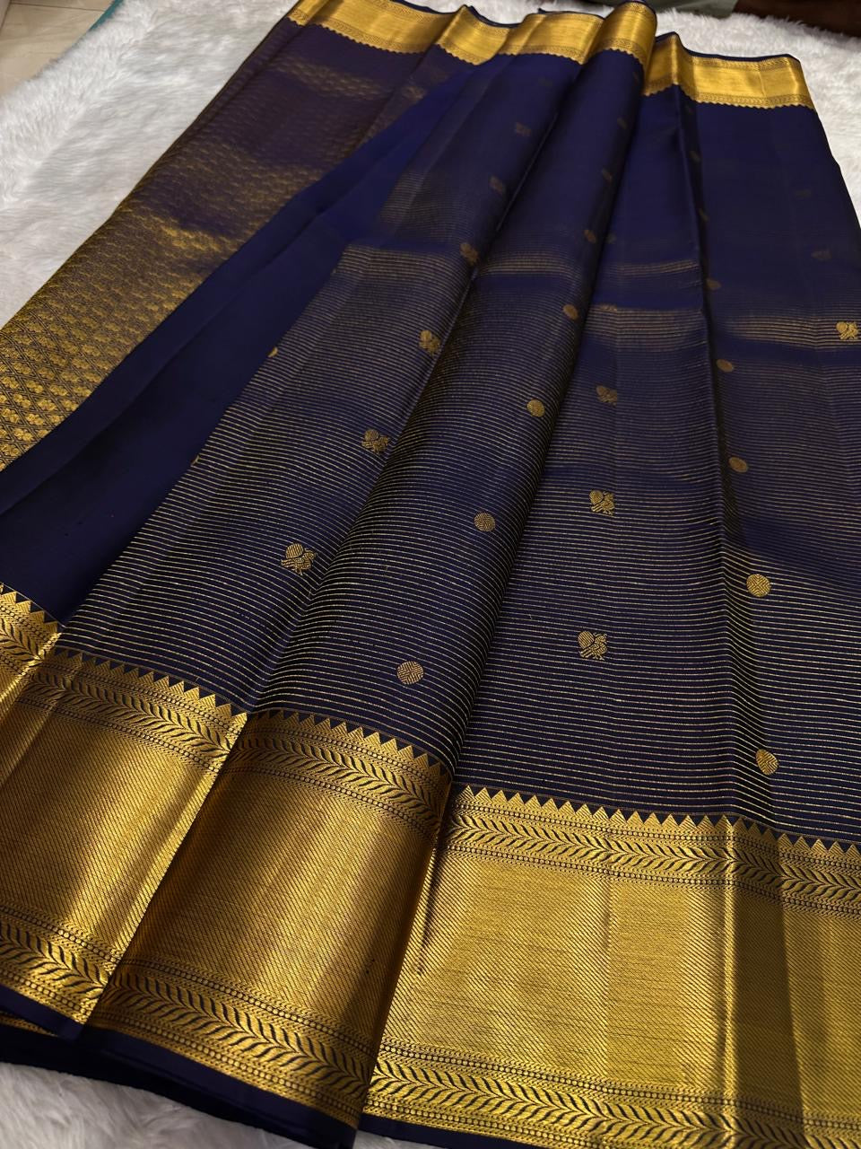Deep indigo Kanchipuram saree — antique-gold temple-inspired border motif close-up