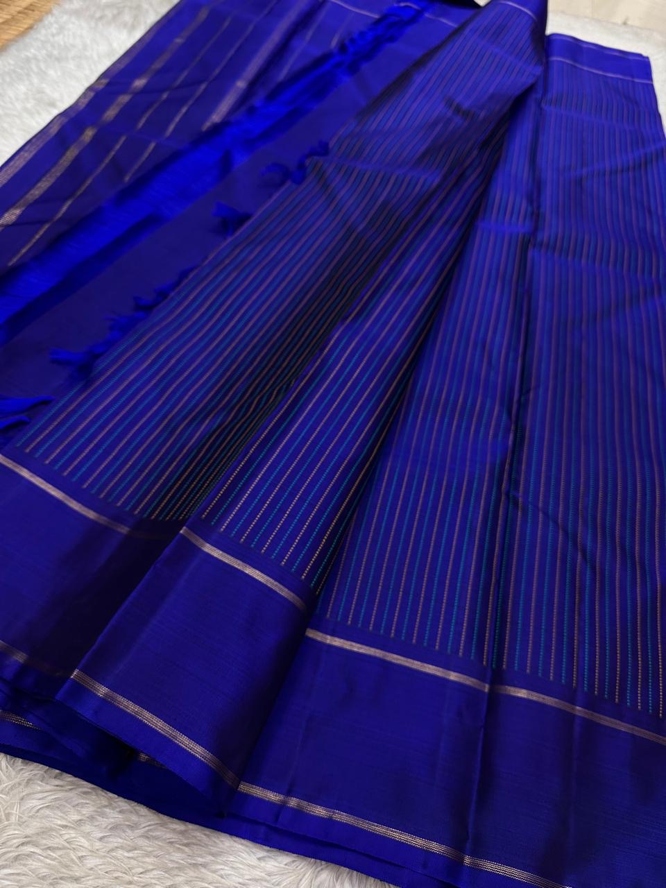 Peacock blue pure silk Kancheepuram saree with delicate linear zari pattern and smooth silk drape detail