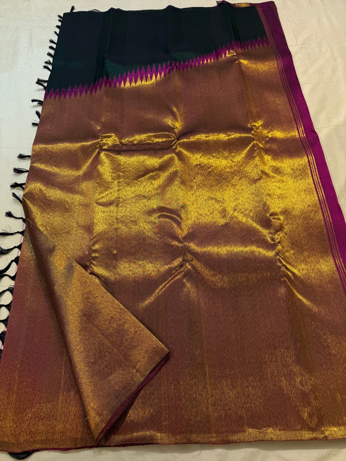 Close-up of the copper-gold Ettukol border on the deep bottle green Kanchipuram silk saree