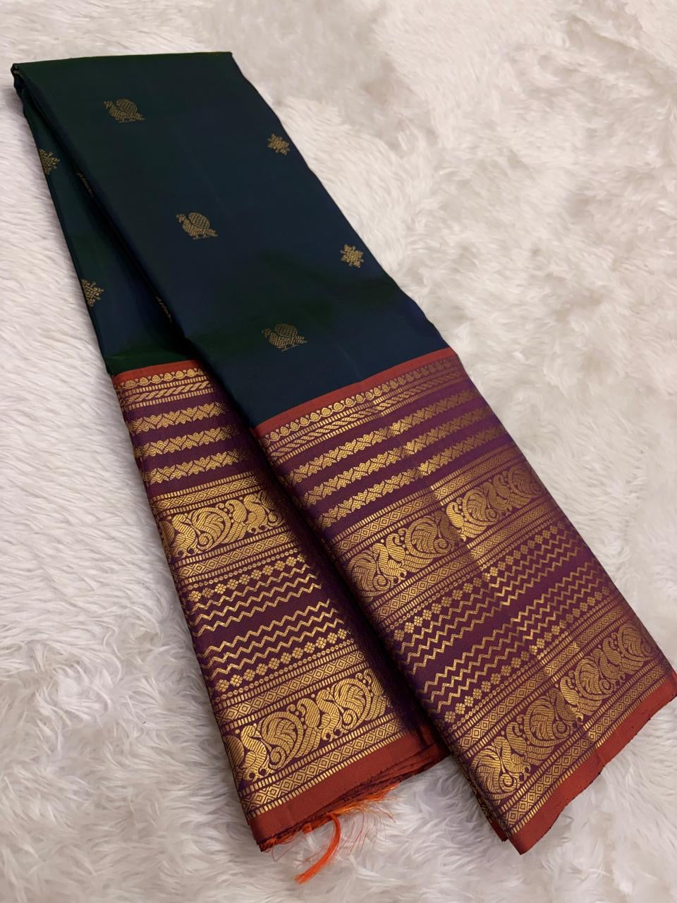 Close view of Varisaipet body showing Mayil Butta in gold zari on deep bottle green silk