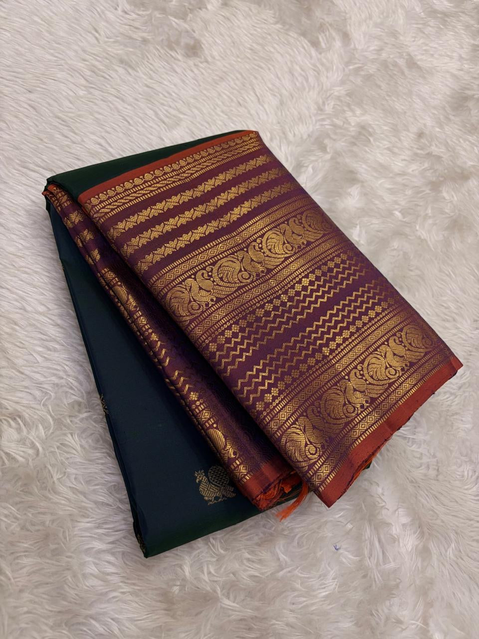 Rust orange Varisaipet border with red silk thread woven motifs on deep bottle green Kanjivaram saree