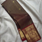 Folded Deep Coffee Brown and Arakku Red Pure Silk Kanchipuram saree showing detailed Gandaberunda gold zari border.
