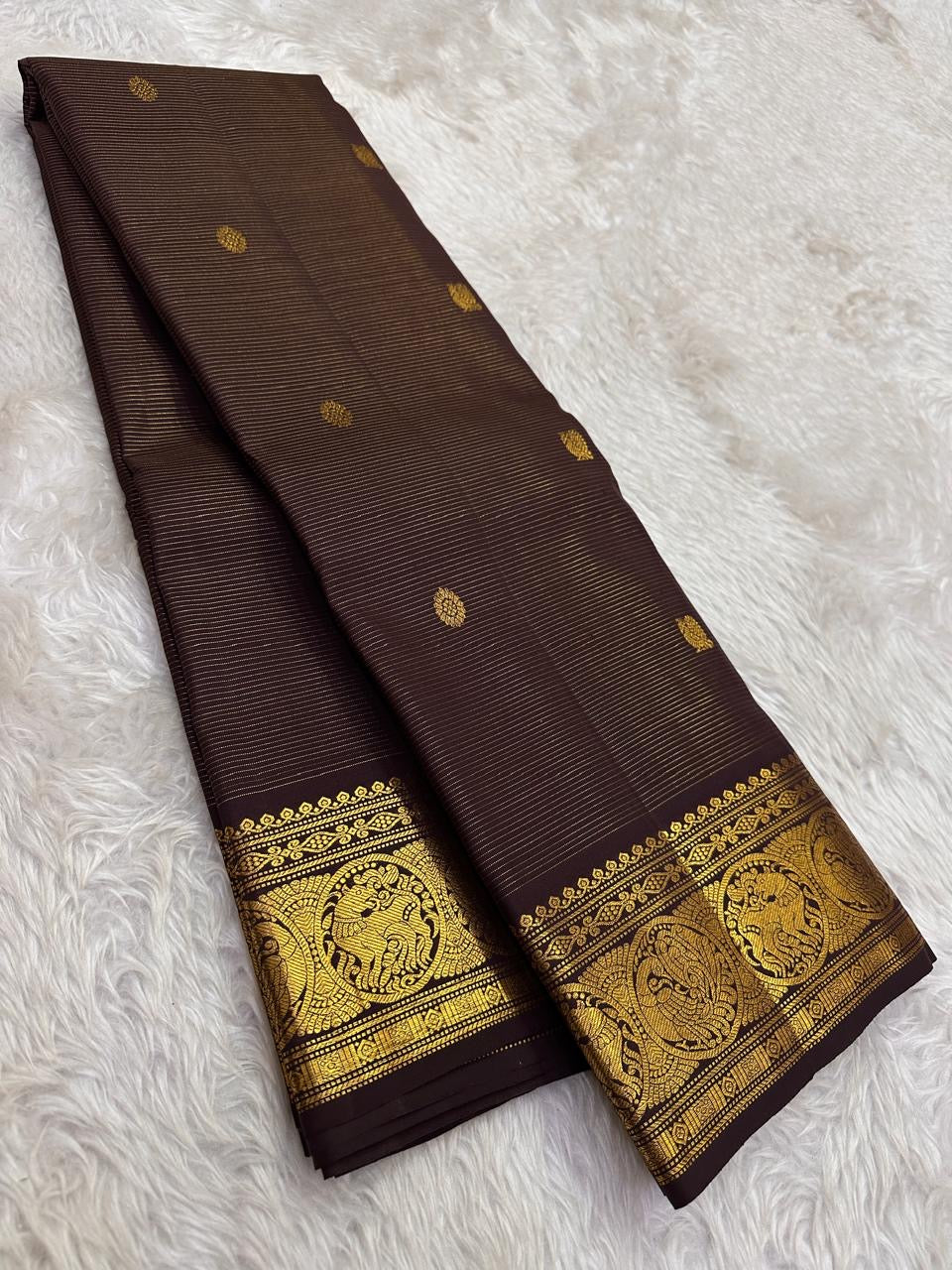 Deep brown Kancheepuram silk saree body close-up showing Vairaoosi fine needle-like zari shimmer and Kamalam lotus gold zari butta
