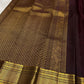 Wide grey-toned zari border framing the deep brown body of Kancheepuram Butta saree