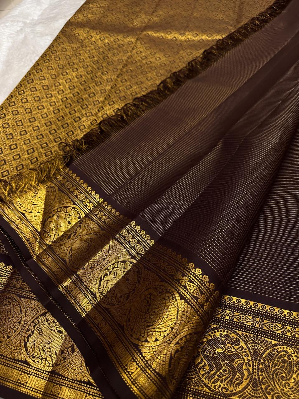 Self-colour pallu of deep brown Kancheepuram pure silk saree with cascading Mayil peacock antique gold zari