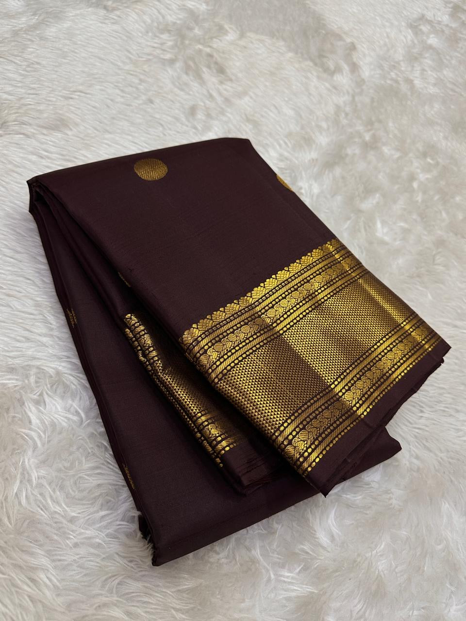 Deep brown Kancheepuram body showing spaced handwoven motifs and substantial metallic border