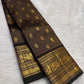 Deep brown lightweight Kanjivaram silk saree body close-up showing Zari Kattam luminous grid and large oval Mayil Chakram gold zari buttas