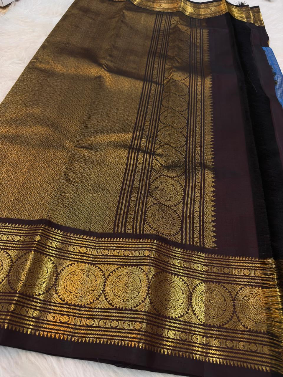 Traditional Mayil peacock border in antique gold on Deep Kanchana Brown Kanjivaram silk.