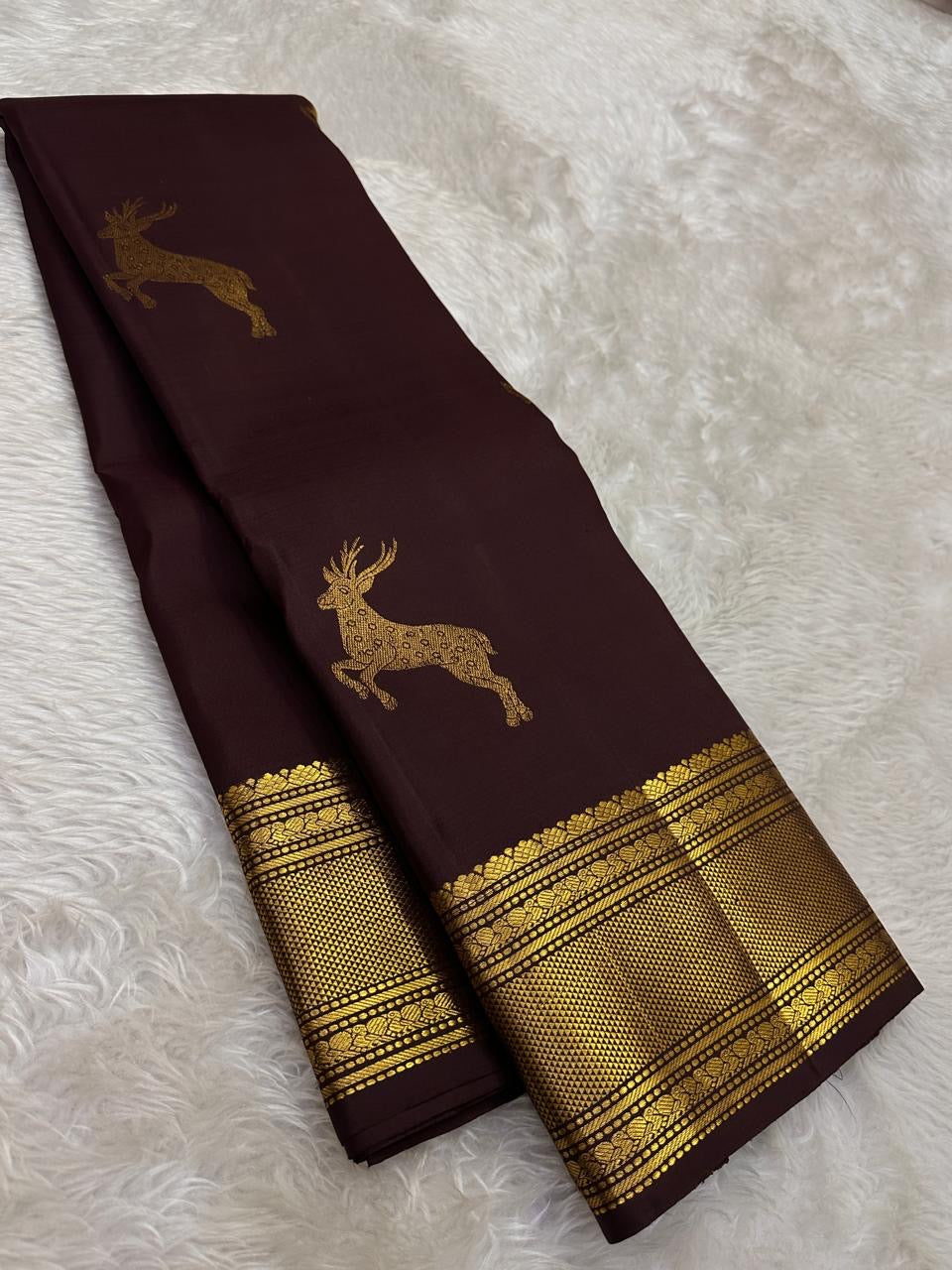 Full view of deep brown Kancheepuram silk with individual buttas and distinctive leaping deer motif