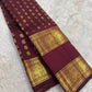 Folded Deep Burgundy Rettapet saree showing petite gold Mail buttas and ornate Yazhi zari border