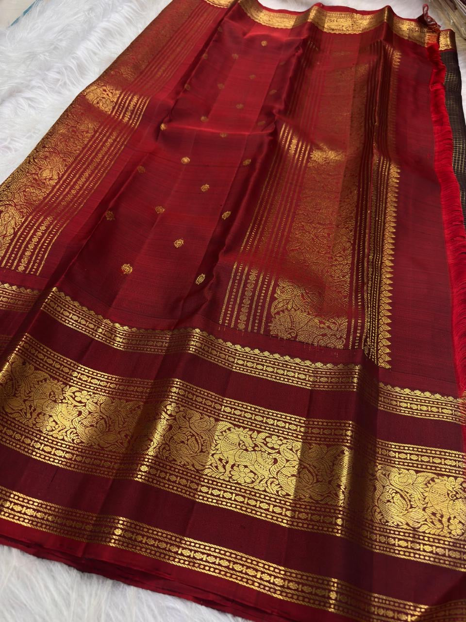 Folded Coffee Brown and Arakku Red Pure Silk Kanchipuram saree showing intricate gold zari border and pallu.