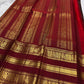 Folded Deep Coffee Brown and Arakku Red Pure Silk Kanchipuram saree with intricate gold zari peacock registers.