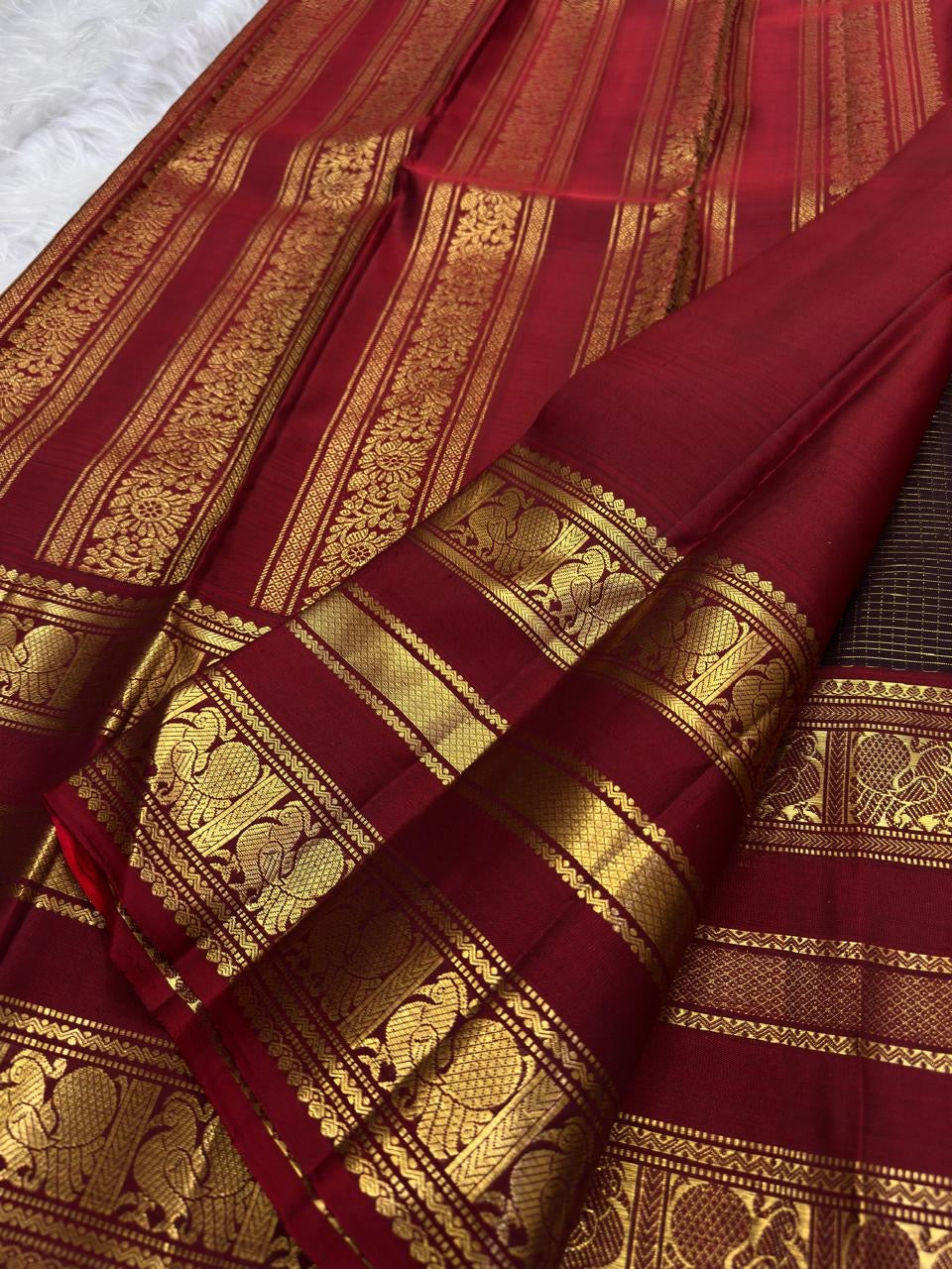 Kanchipuram Zari Kattam saree showing Coffee Brown checked body and detailed Arakku Red Mayil border.