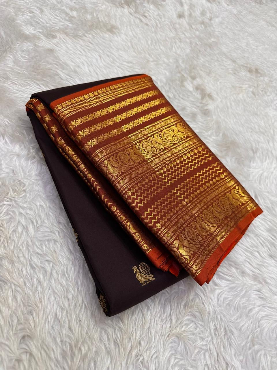 Rust orange Varisaipet border with red silk thread woven motifs on espresso brown Kanjeevaram saree