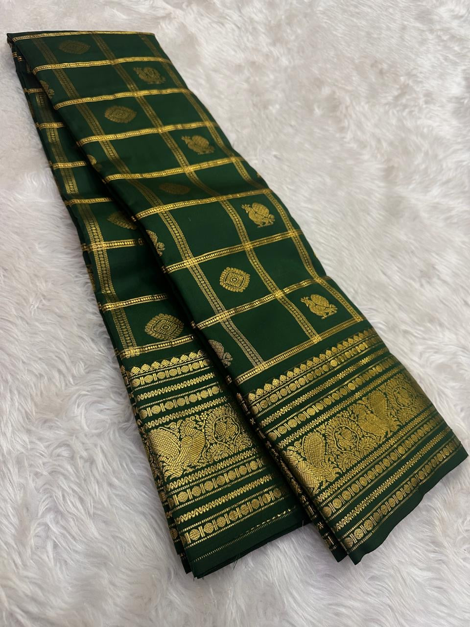 Deep Forest Green Kanjivaram silk saree showing broad handwoven gold zari peacock border