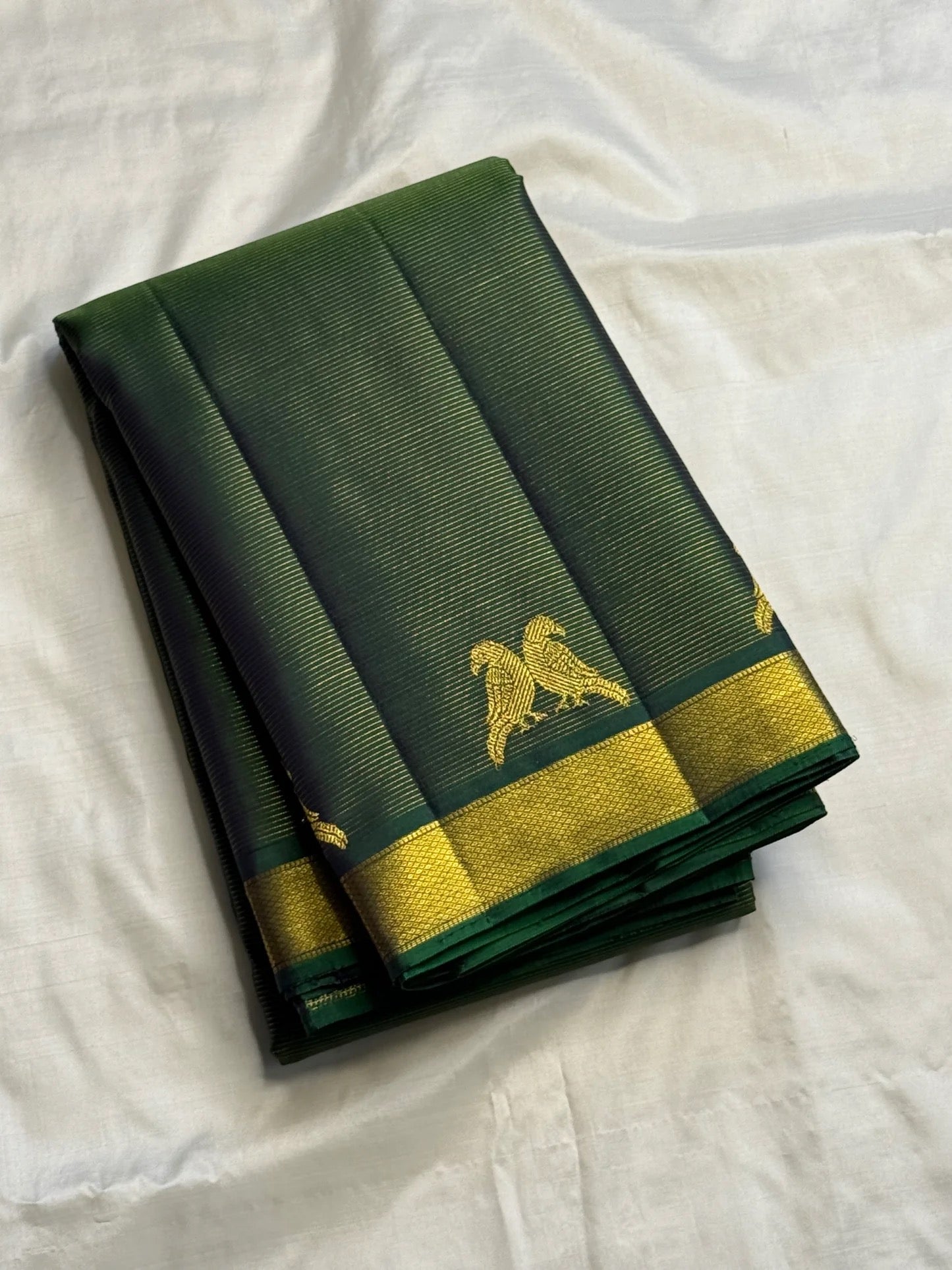 Deep Forest Green Kanchipuram saree with handwoven Kili zari motifs.