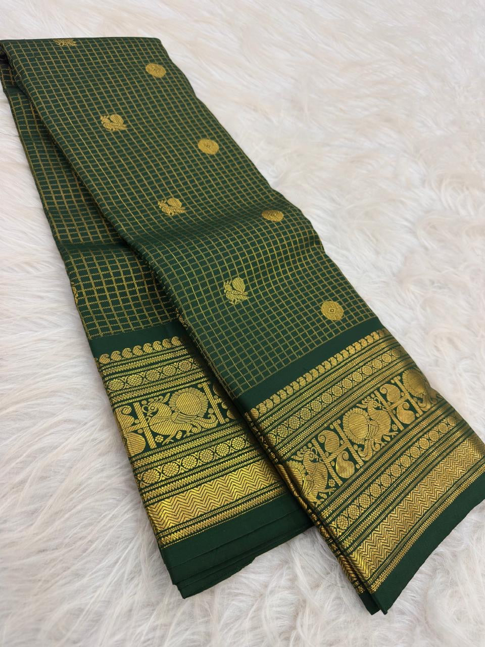 Deep green Kanjeevaram saree with ornate gold border