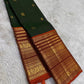 Rust orange pallu with red silk thread motifs on deep forest green Varisaipet saree