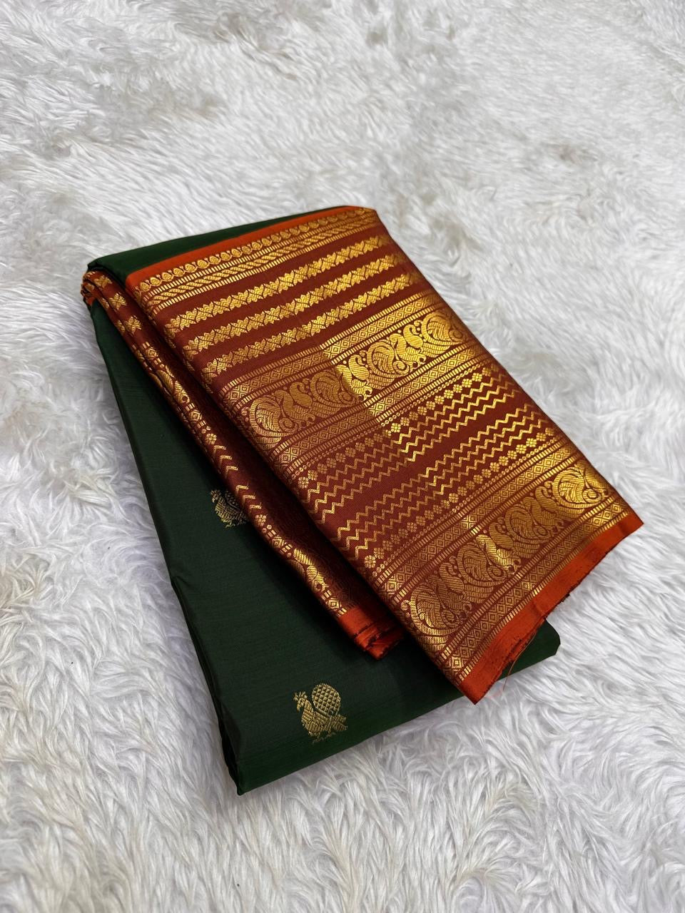 Close view of Varisaipet body showing Mayil Butta in gold zari on deep forest green silk