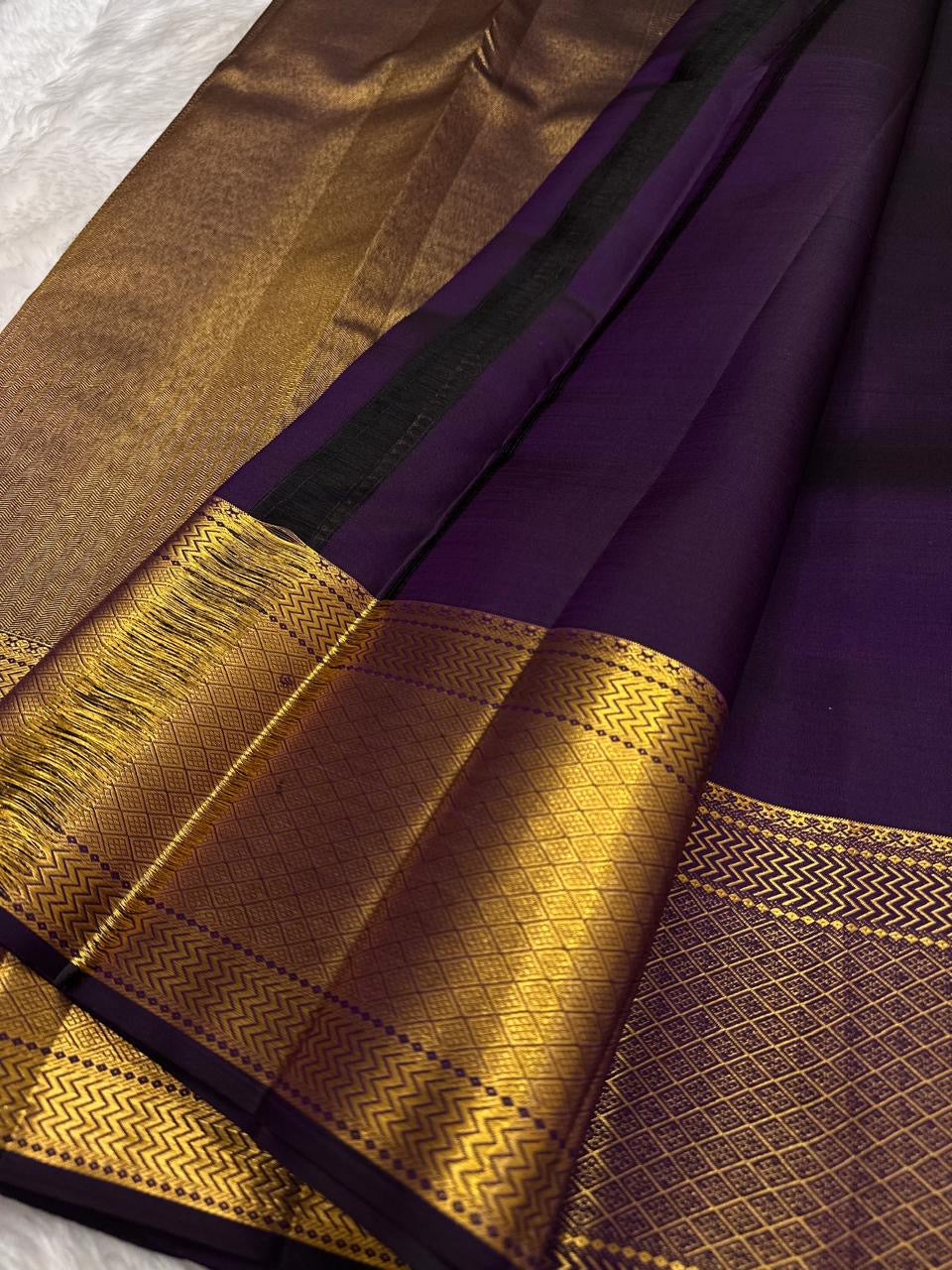Folded view of deep grape purple pure silk Zari Kattam Kanchi Pattu saree with Gandaberunda Butta