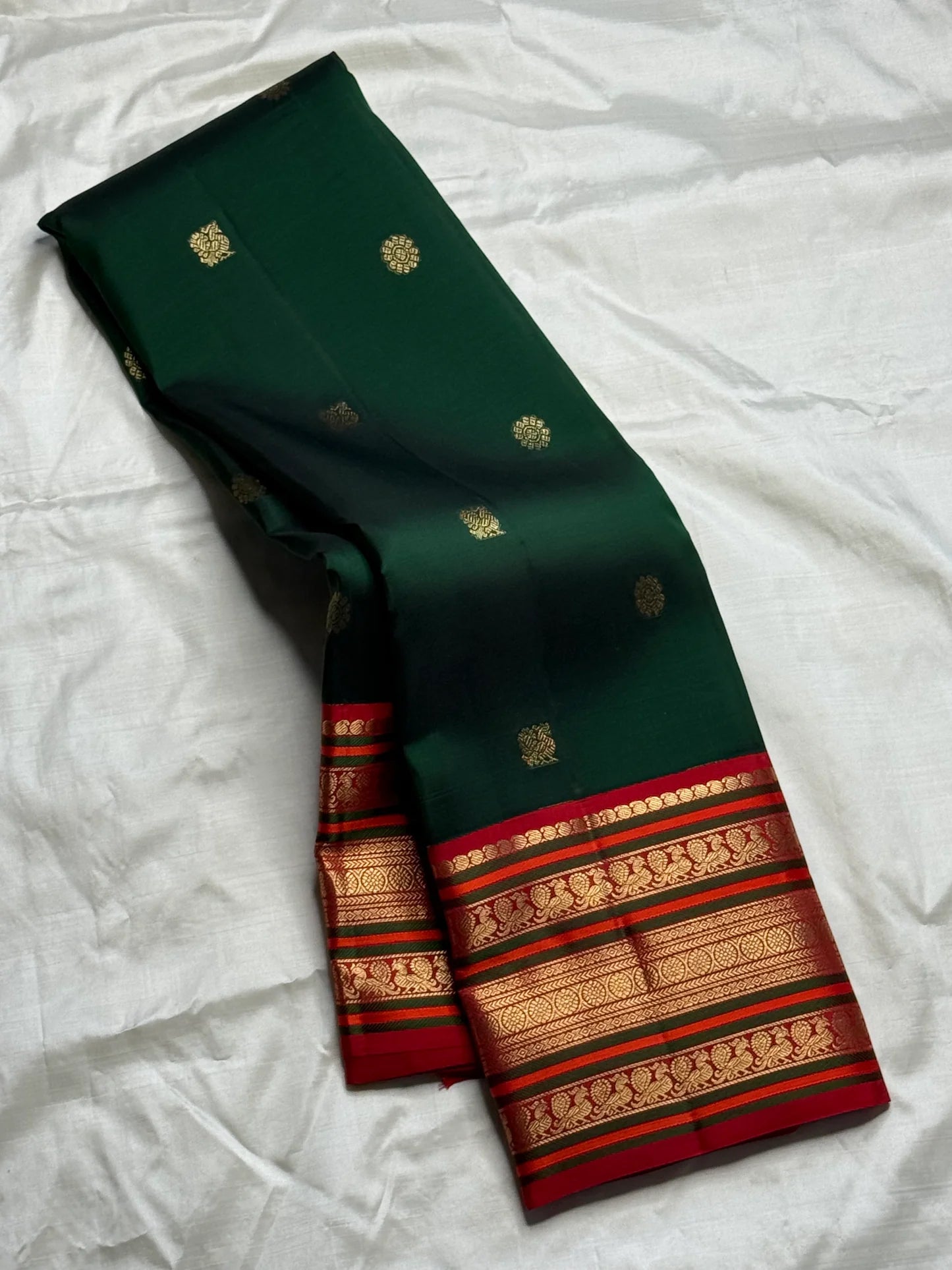 Deep green and chili red Kanchipuram silk saree draped to show full border and silk sheen — Idam Living