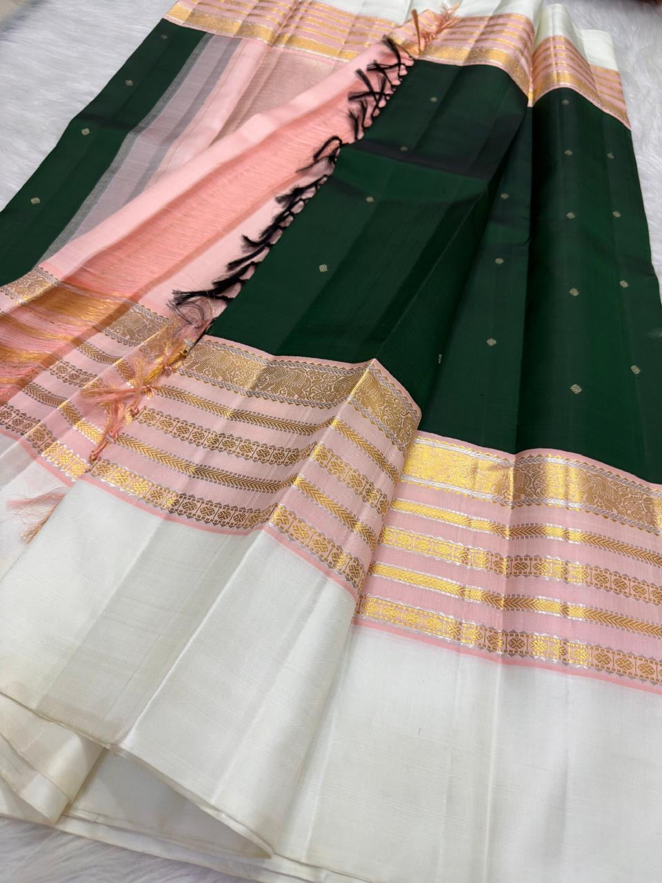 Deep Green Kancheepuram saree with Ivory Petal Pink Pettu, Maanga medallions and fine gold Seer bands