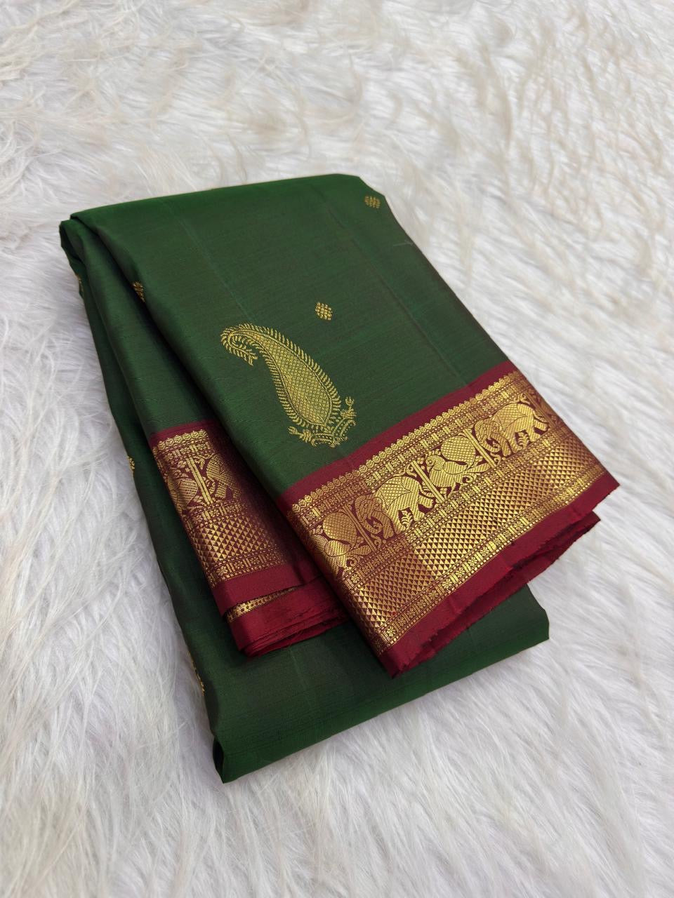 Deep Green Kanchipuram silk saree showing large reinterpreted maanga motifs balanced by smaller baby zari buttas placed across the deep green body.