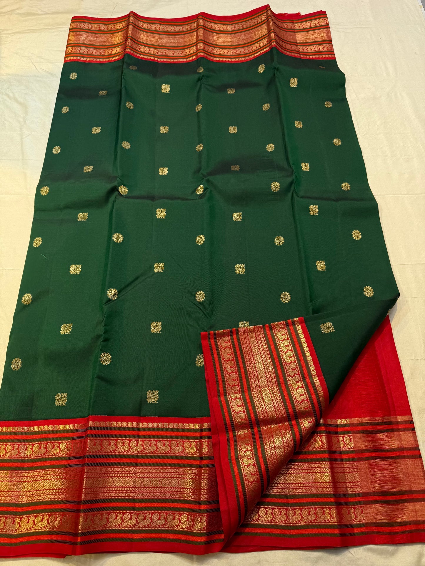 Folded deep green Kanchipuram silk saree showing rich silk body with gold zari buttas and red border — Idam Living