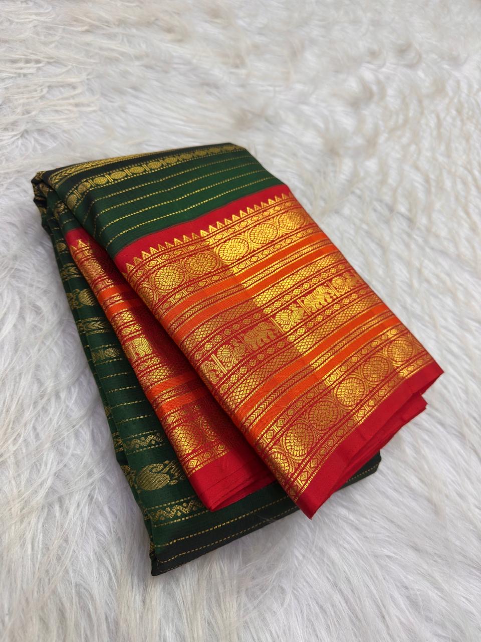 Full drape view highlighting the green body, contrast border and traditional zari workmanship.