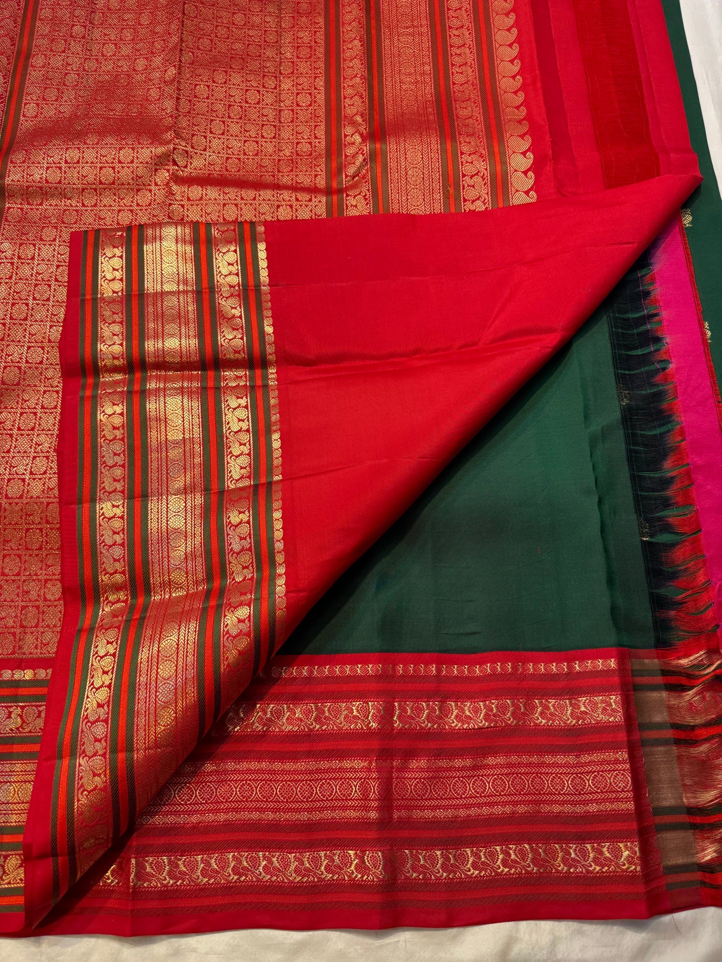Deep green Kanjivaram silk saree with scattered gold zari motifs and traditional chili red zari border — Idam Living