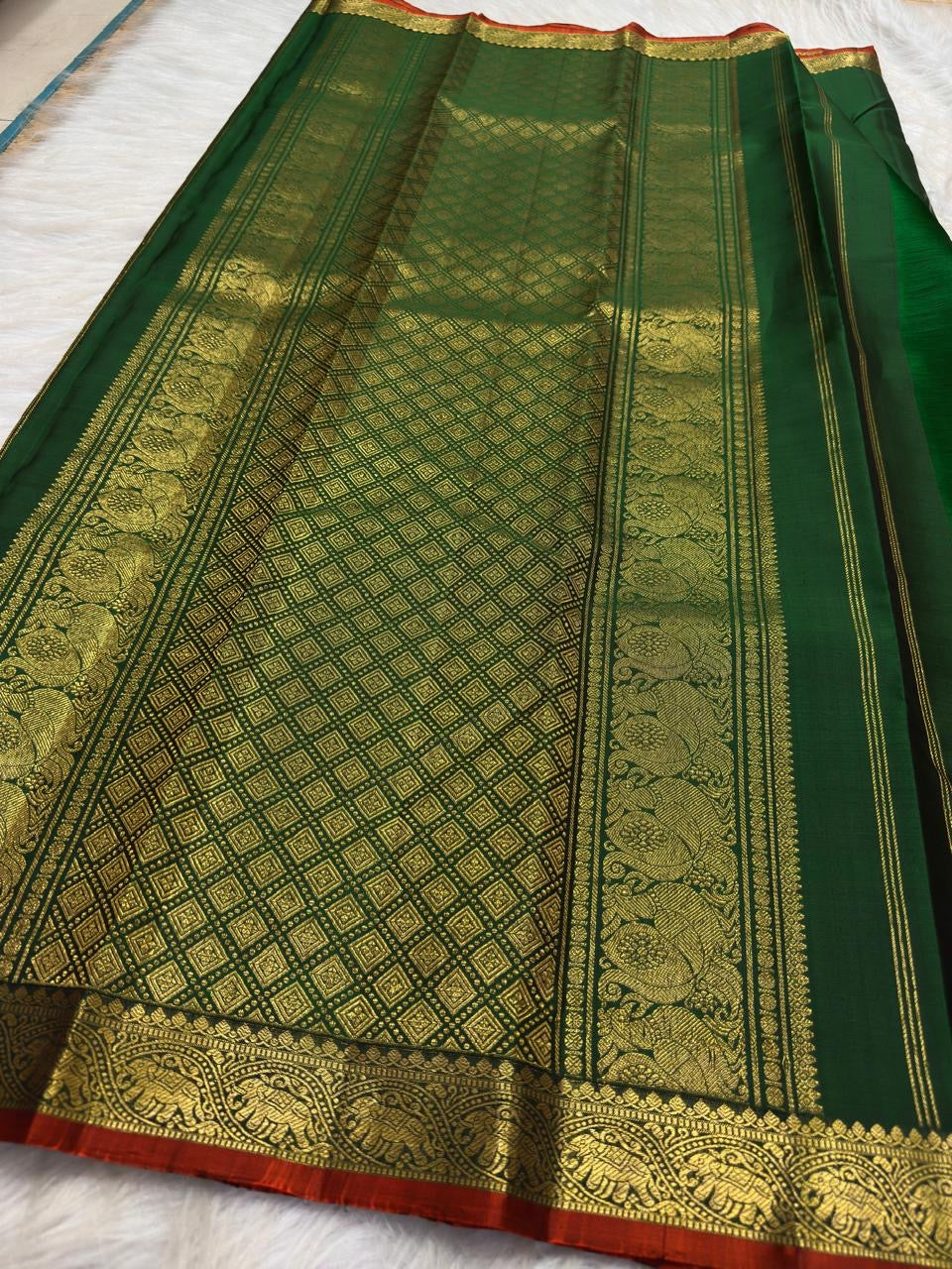 Deep Emerald Green pure silk Kanjivaram Butta saree with Arakku Red finishing edge.